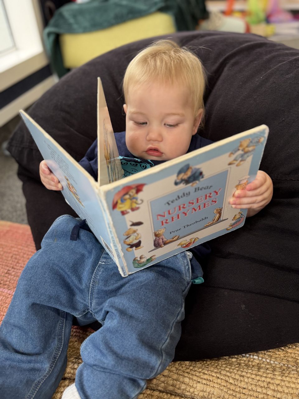 A young child independently looking through a picture book