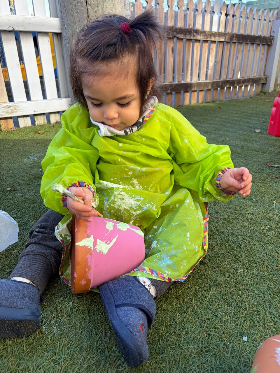 A child painting outdoors at The Miller Nest